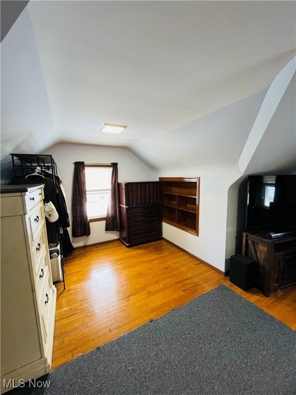 bonus room with lofted ceiling and light hardwood / wood-style floors