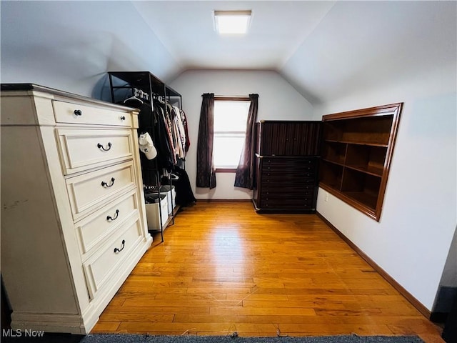 walk in closet with lofted ceiling and light wood-type flooring