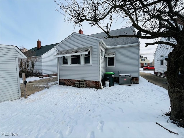 snow covered house with central AC unit