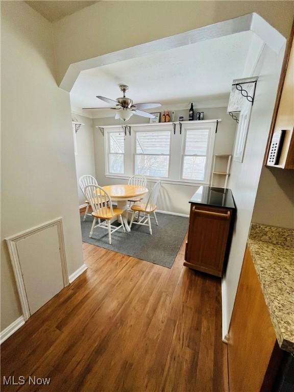 dining space featuring ceiling fan and dark hardwood / wood-style flooring