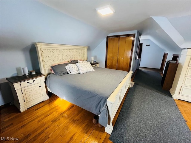 bedroom with lofted ceiling and dark hardwood / wood-style floors