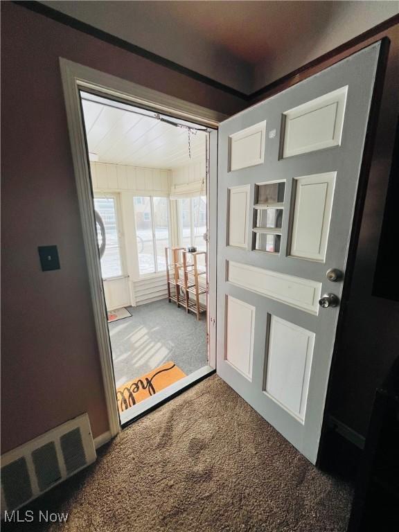 doorway to outside with carpet floors