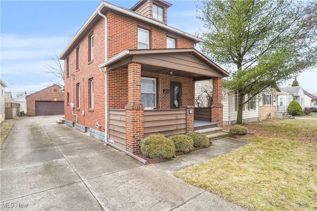 view of front of house featuring an outbuilding, a garage, a front yard, and a porch