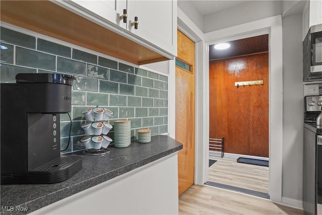 kitchen featuring white cabinets, light hardwood / wood-style floors, and decorative backsplash