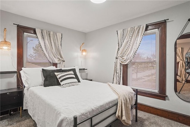 bedroom with multiple windows and dark colored carpet