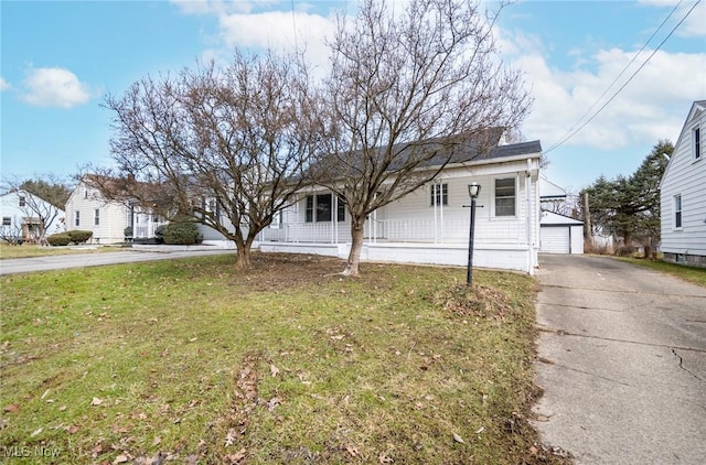 view of front of house featuring a garage, an outbuilding, and a front yard