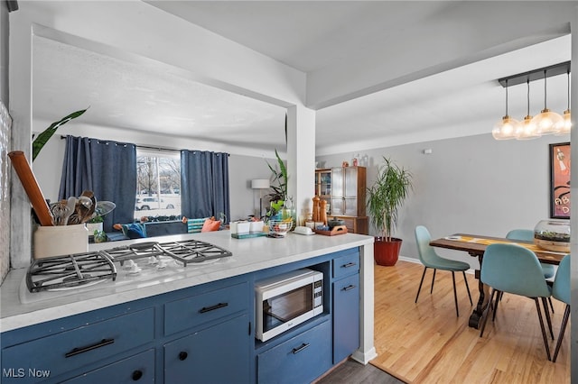 kitchen featuring dark hardwood / wood-style flooring, gas stovetop, decorative light fixtures, and blue cabinets