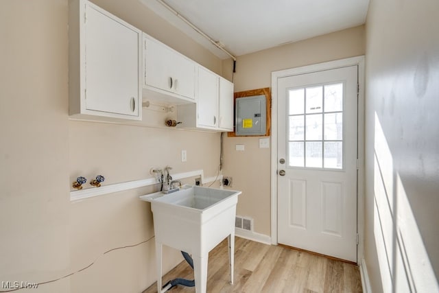 laundry area featuring electric dryer hookup, hookup for a washing machine, electric panel, and light wood-type flooring