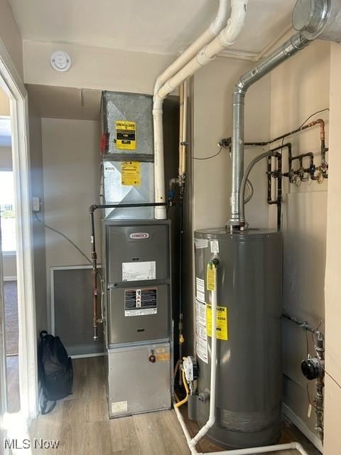 utility room featuring gas water heater and heating unit