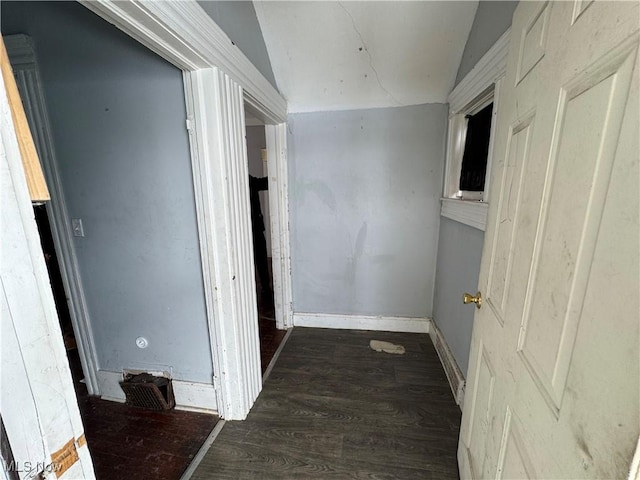 corridor featuring vaulted ceiling and dark hardwood / wood-style floors