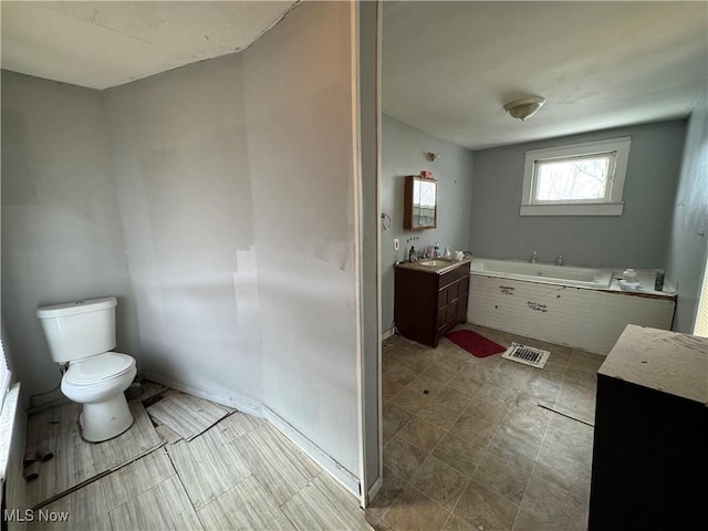 bathroom with vanity, a bathtub, and toilet