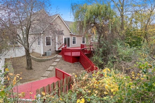 rear view of house with cooling unit and a wooden deck