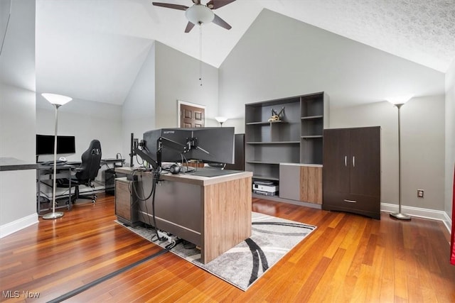 office space featuring hardwood / wood-style flooring, ceiling fan, high vaulted ceiling, and a textured ceiling