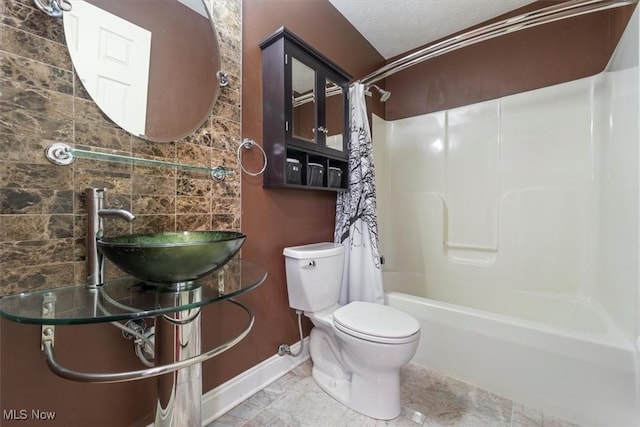 full bathroom featuring toilet, shower / bathtub combination with curtain, and sink