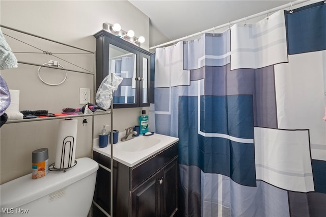 bathroom with walk in shower, vanity, and toilet