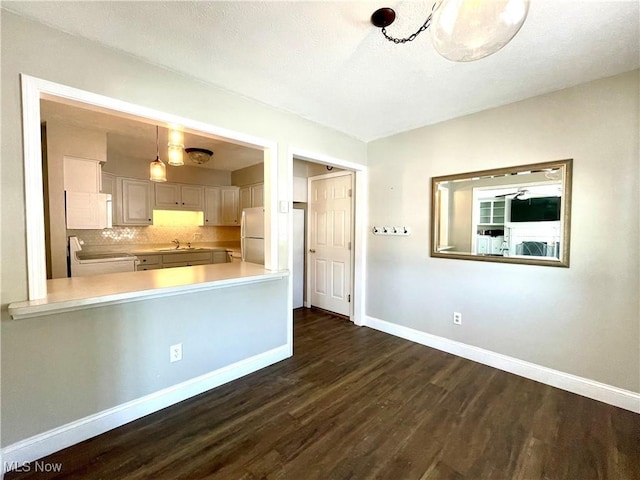 kitchen with sink, stainless steel refrigerator, stove, tasteful backsplash, and dark hardwood / wood-style flooring