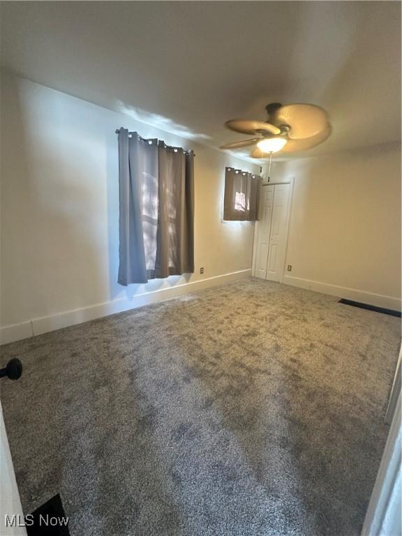 carpeted empty room featuring ceiling fan