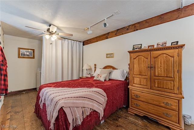 bedroom with dark hardwood / wood-style flooring, a textured ceiling, rail lighting, and ceiling fan