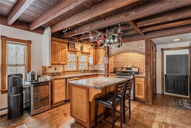 kitchen featuring a kitchen island, appliances with stainless steel finishes, sink, wooden ceiling, and beam ceiling