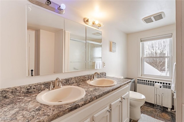 bathroom featuring vanity, a shower with shower door, radiator heating unit, and toilet