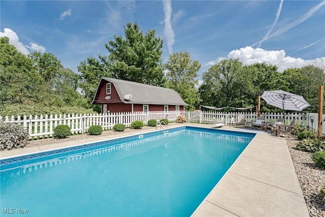 view of swimming pool with a diving board and a patio