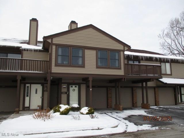 view of front of property featuring a balcony and a garage