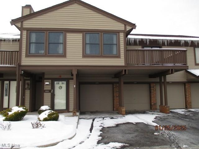 view of front of property featuring a garage and a balcony