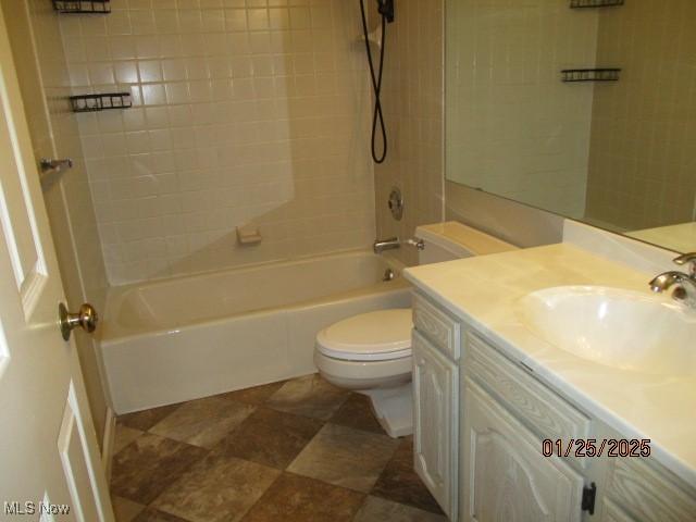 full bathroom featuring vanity, tiled shower / bath combo, and toilet