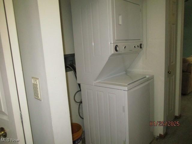 washroom featuring stacked washer and clothes dryer