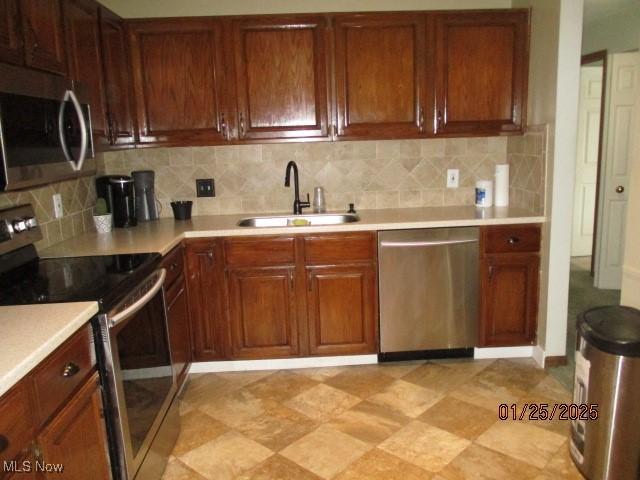 kitchen featuring sink, backsplash, and appliances with stainless steel finishes