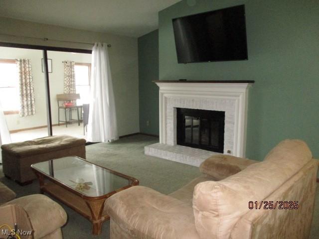 carpeted living room with a brick fireplace