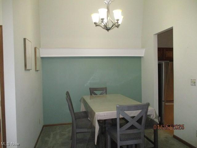 carpeted dining area with an inviting chandelier