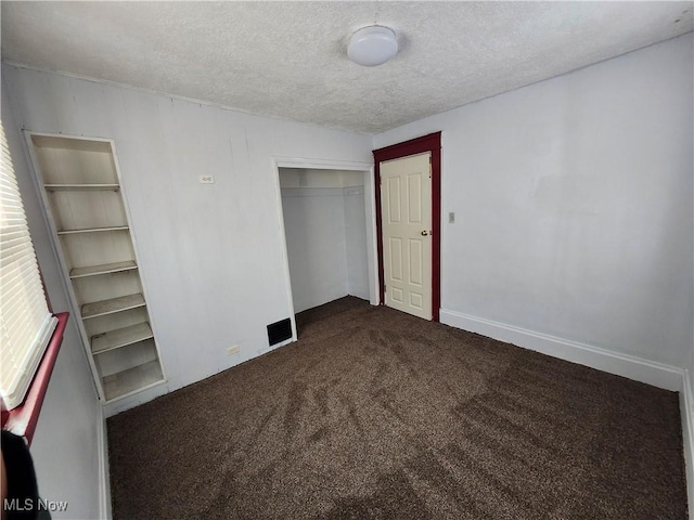 unfurnished bedroom with a closet, a textured ceiling, and carpet