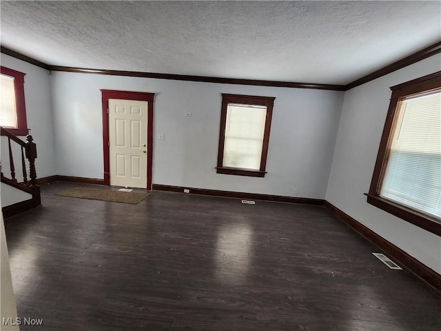 spare room featuring ornamental molding, plenty of natural light, and dark hardwood / wood-style flooring