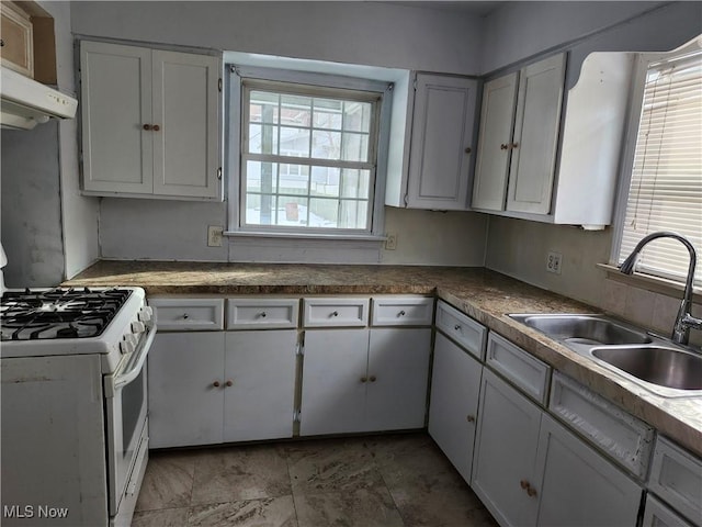 kitchen with sink, gas range gas stove, and white cabinets