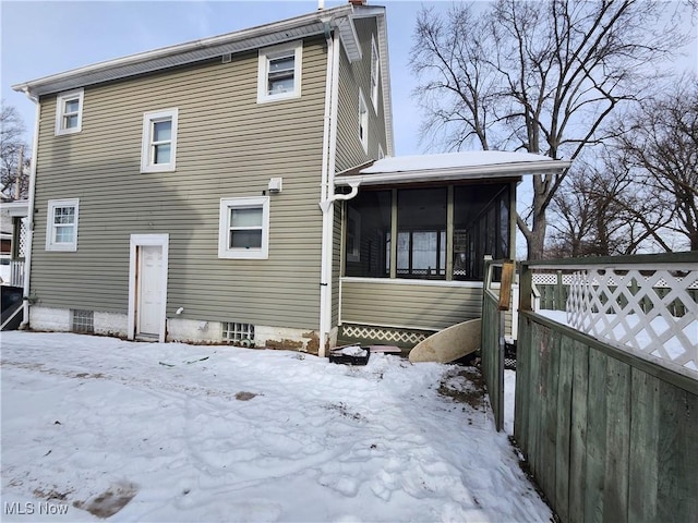 snow covered property featuring a sunroom