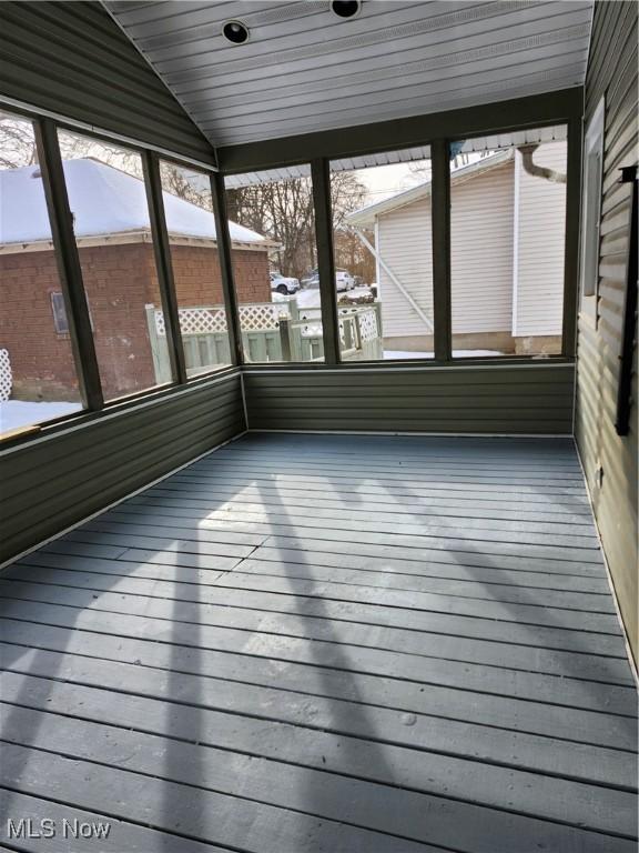 unfurnished sunroom featuring lofted ceiling, wood ceiling, and a wealth of natural light