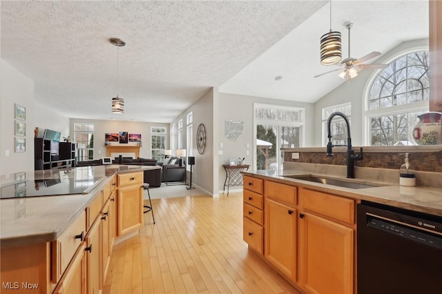 kitchen featuring decorative light fixtures, sink, a textured ceiling, and black appliances