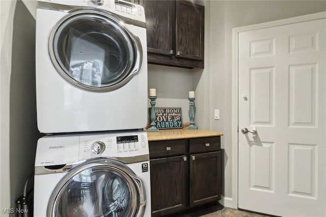 laundry room with cabinets and stacked washer and dryer