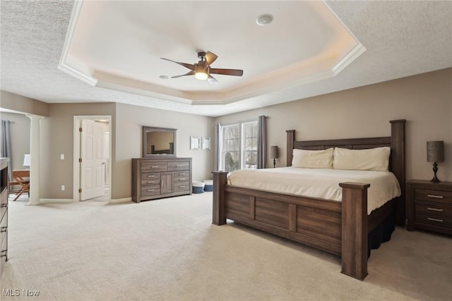 bedroom with ceiling fan, a raised ceiling, decorative columns, and light carpet