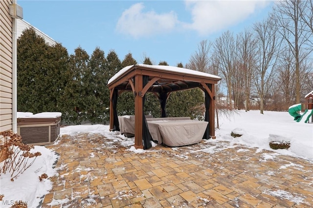 snow covered patio featuring a gazebo and a hot tub