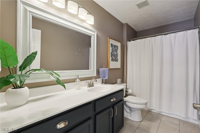 bathroom featuring vanity, tile patterned floors, toilet, and a textured ceiling