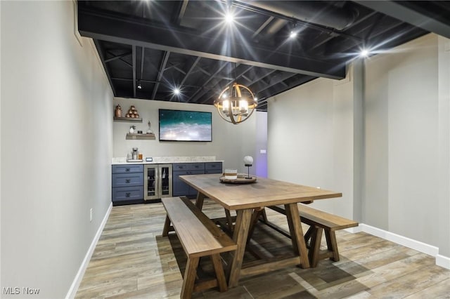 dining room with light hardwood / wood-style flooring, beverage cooler, and indoor bar