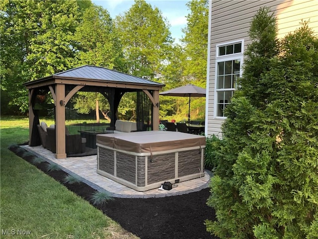 view of patio / terrace with a hot tub, a gazebo, and outdoor lounge area