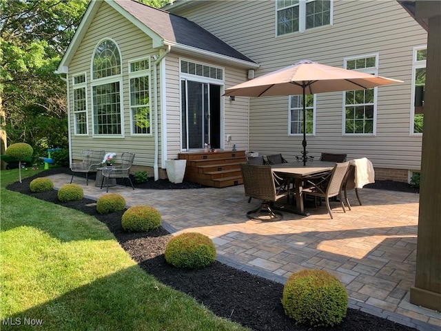 rear view of property featuring a lawn and a patio