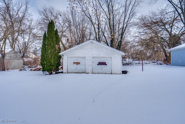 snow covered structure featuring a garage