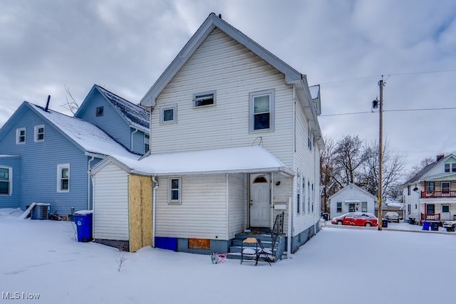 snow covered back of property with central air condition unit