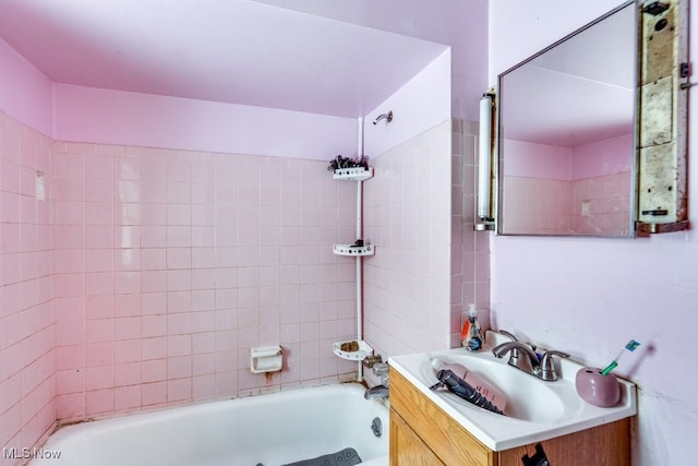 bathroom featuring vanity and tiled shower / bath