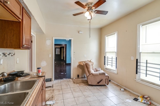 sitting room featuring sink, light tile patterned floors, and ceiling fan