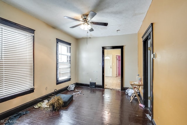 unfurnished bedroom featuring dark hardwood / wood-style floors, a textured ceiling, and ceiling fan